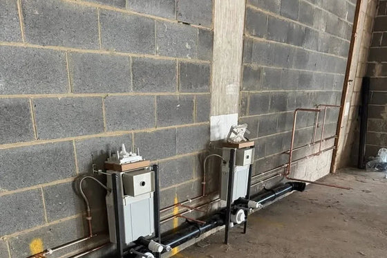 Two commercial gas meters installed with the pipework run in