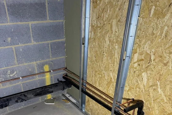 Gas pipework run through a steel stud partition on a commercial site