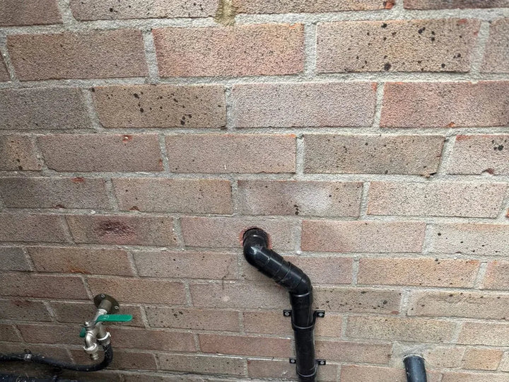 External waste pipework and an outside tap installed on a rear wall