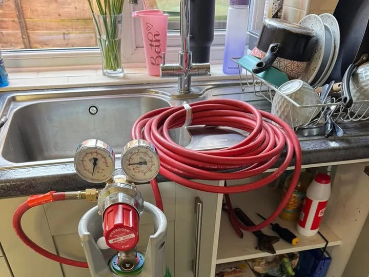 Tracer gas cylinder set up indoors to pinpoint a hidden water leak